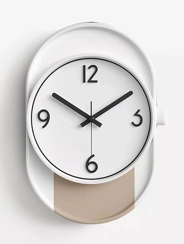The image shows a white, round clock with black hands and numerals. The clock face is set against a pale brown background, creating a modern and minimalist design. The clock is suspended in mid-air, suggesting a sense of timelessness. The clock's design is simple, yet elegant, and the clean lines are visually appealing.