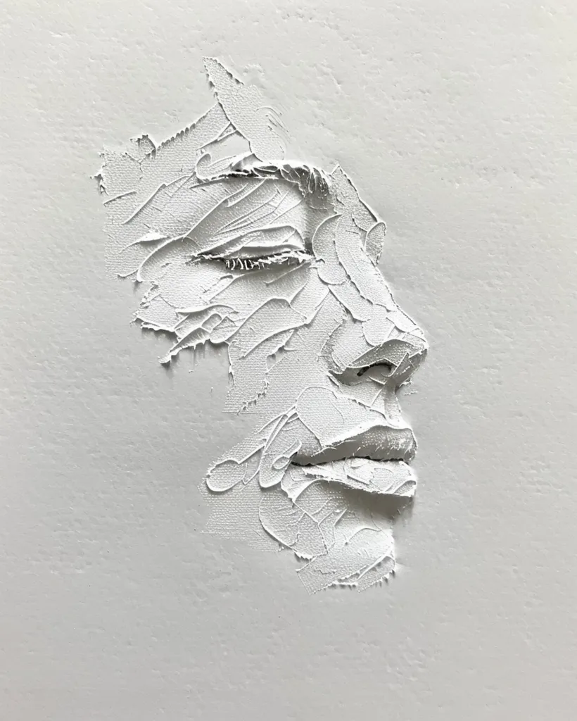 The image is a close-up of a white, textured, abstract portrait. The face is created with thick, layered paint strokes, giving it a three-dimensional appearance. The subject's eyes are closed, and their mouth is slightly parted. The overall effect is one of peace and tranquility.