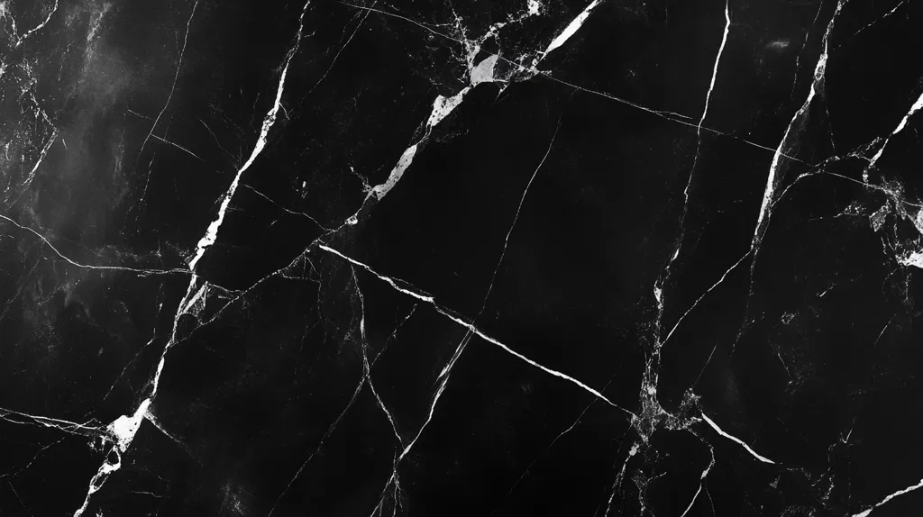 The image is a close-up shot of a black marble surface. The marble has a dark, almost black background with a network of white veins and cracks running through it. The veins are thin and delicate, creating a subtle pattern on the surface. The overall effect is one of elegant simplicity and understated beauty. The black marble surface is a popular choice for countertops, flooring, and other decorative applications.