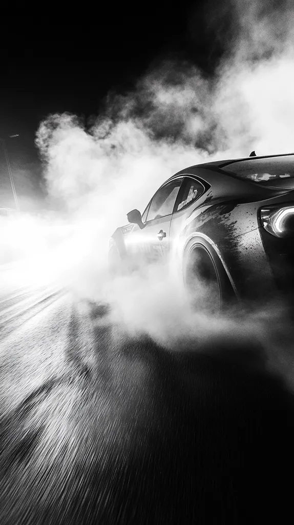A black and white image of a car driving on a wet road, leaving behind a trail of smoke and a blurred background. The car is a sports car with a sleek design and large wheels. The image is captured in a low-angle shot, emphasizing the car's speed and the dynamic motion of the smoke. The contrast between the dark car and the white smoke creates a dramatic effect.