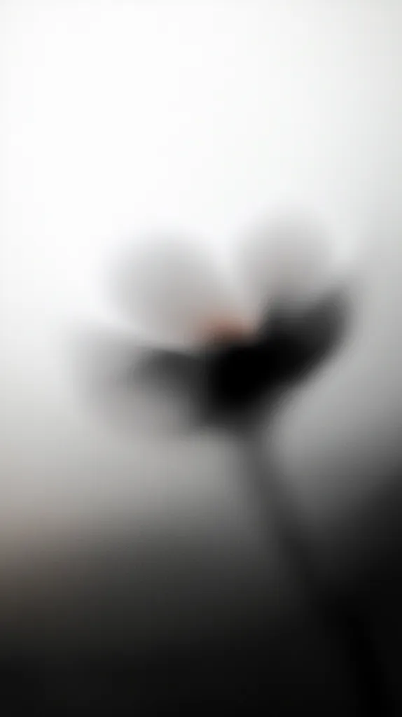 The image is a blurry, out-of-focus shot of a flower. It is likely a white flower with a darker center, but its features are obscured by the blur. The background is also blurred, creating a soft, ethereal effect. The image evokes a sense of mystery and intrigue, as the flower's details are hidden from view.  The soft focus and muted tones create a dreamlike atmosphere.