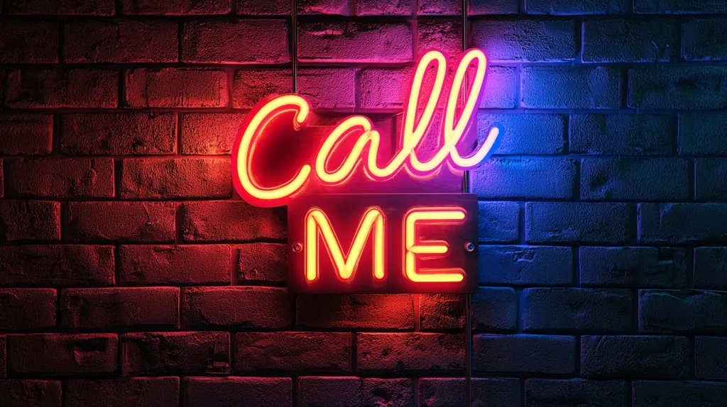 A vibrant neon sign, reading "Call Me," is mounted on a dark brick wall.  The "Call" portion is a stylized script, with a color gradient shifting from red to purple. "Me" is displayed below in a simpler, bold font, glowing a consistent reddish-orange. The contrast between the bright neon and the dim brick wall creates a striking visual effect, suggesting a retro or nightlife atmosphere.