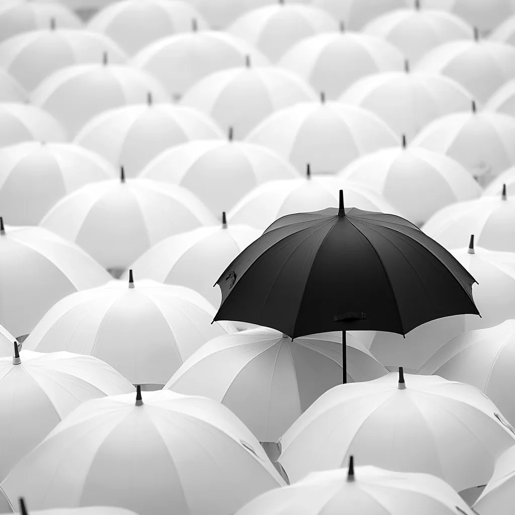 A single black umbrella stands out amongst a sea of white umbrellas. The black umbrella is centrally positioned, emphasizing its difference from the uniformity of the surrounding white umbrellas. The image suggests themes of individuality, standing out from the crowd, and nonconformity.  The monochrome palette enhances the contrast and visual impact.