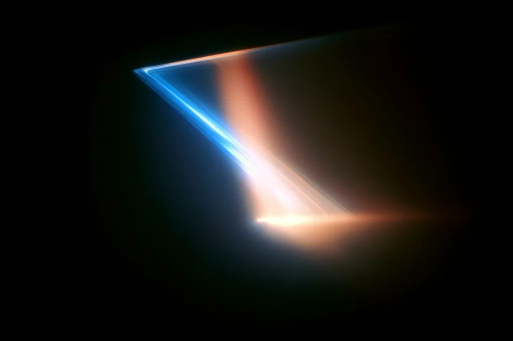 The image showcases an abstract light effect, predominantly dark with a striking diagonal beam of light.  The beam transitions from a vibrant, cool blue at its origin to a warmer, orange-hued glow as it spreads across the lower portion of the frame.  The contrast between the cool and warm tones creates a dynamic visual experience against the deep black background. The overall impression is one of energy and motion.