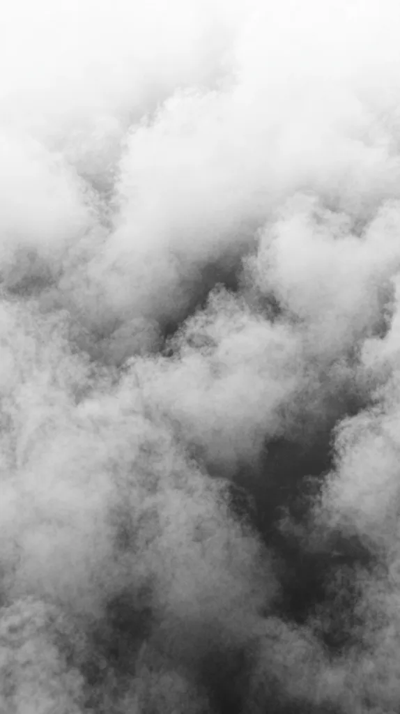 A grayscale image depicts a dense collection of clouds, appearing soft and fluffy.  The clouds vary in density, creating a textured effect with lighter and darker shades of gray.  The overall mood is serene and somewhat ethereal, with a lack of sharp lines or defined shapes.  The clouds fill the entire frame, suggesting a vast expanse of sky.