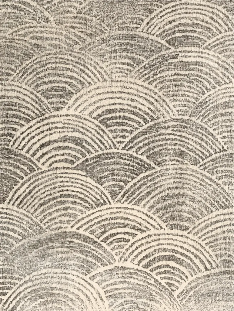 The image shows a textured surface with a repeating pattern of overlapping semi-circles. The semi-circles are dark grey against a lighter, off-white background, creating a wave-like effect.  The pattern has a slightly distressed or aged look, adding to its vintage appeal.  The overall style is minimalist and geometric, with a subtle elegance.