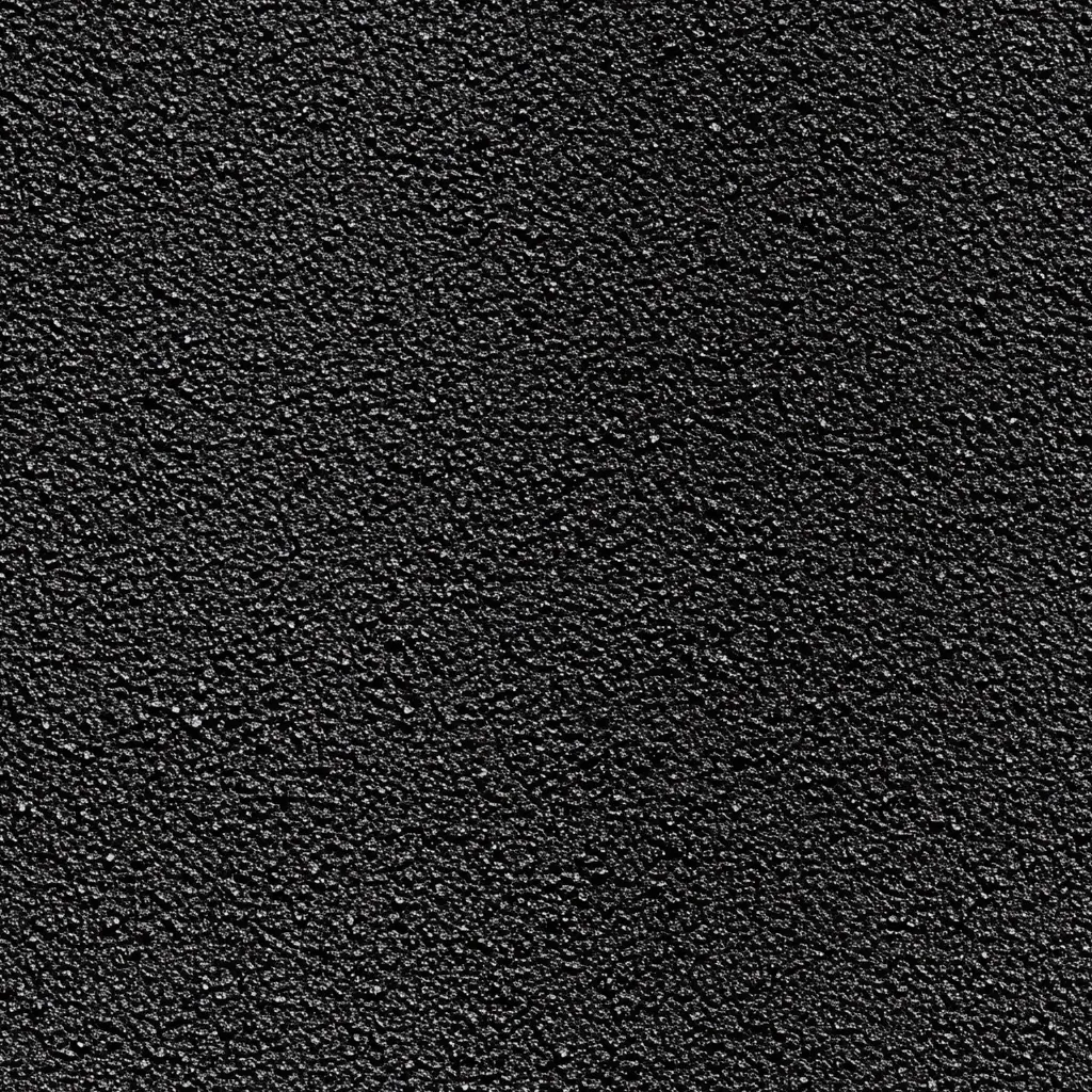 The image shows a close-up view of a textured surface.  It appears to be a dark gray or black material with a granular or pebbled texture.  The surface is uniformly covered with small, closely packed particles, creating a rough, slightly uneven appearance.  The overall impression is one of darkness and a coarse, almost gritty feel.
