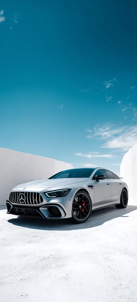 A sleek, silver Mercedes-AMG GT 63 S 4MATIC+ coupe is parked on a bright white surface under a vibrant blue sky. The car's sharp lines and aggressive stance are emphasized by the minimalist background.  The setting suggests a modern, luxurious feel, highlighting the vehicle's powerful design and high-performance capabilities.