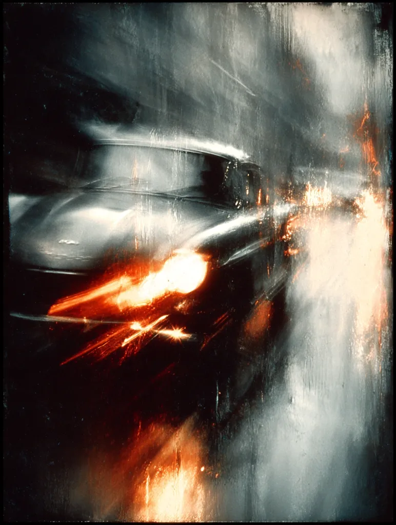 An abstract painting depicts a car speeding through a blurred, nighttime city.  The vehicle is rendered in dark tones, its headlights glowing intensely, creating streaks of orange and white light across the canvas.  The background is a hazy mix of grays and whites, suggesting motion and speed. The overall effect is dynamic and evocative of urban energy.