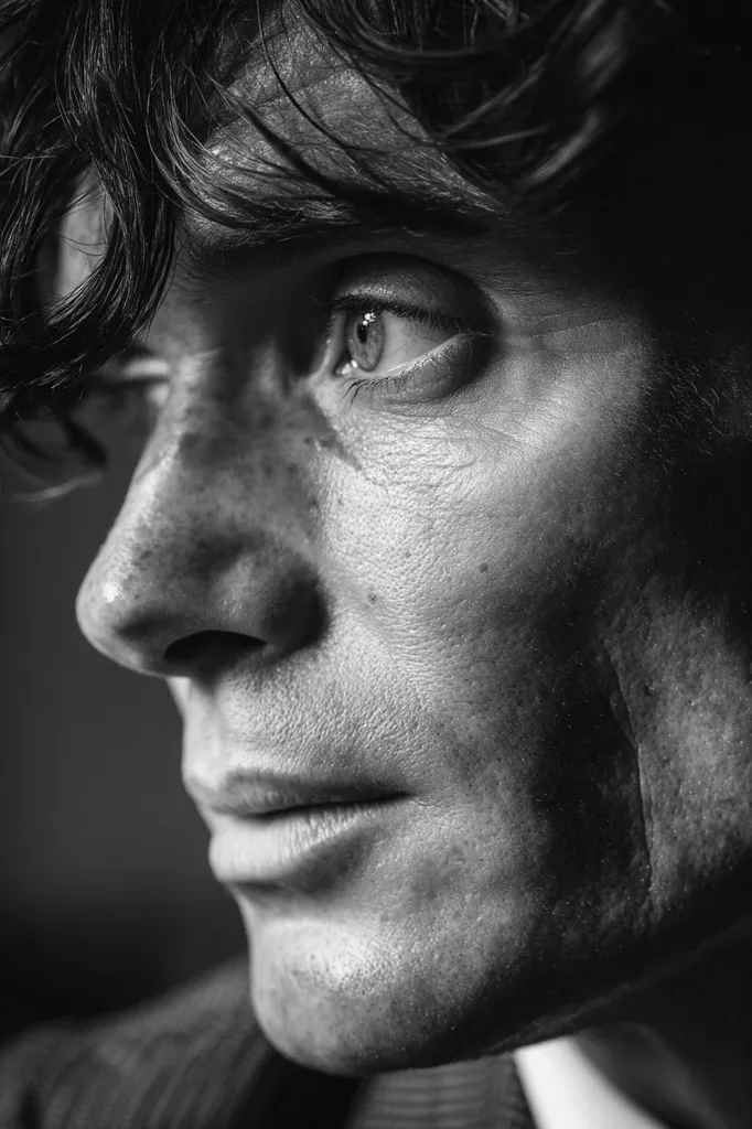 A black and white close-up portrait captures a man's face, his gaze directed to the right.  His dark hair falls across his forehead, partially obscuring his eyes.  The photograph emphasizes the texture of his skin, showcasing fine lines and subtle shadows.  A thoughtful or pensive expression is conveyed through his partially open lips and the subtle crease of his brow.  The lighting is dramatic, highlighting the contours of his face.