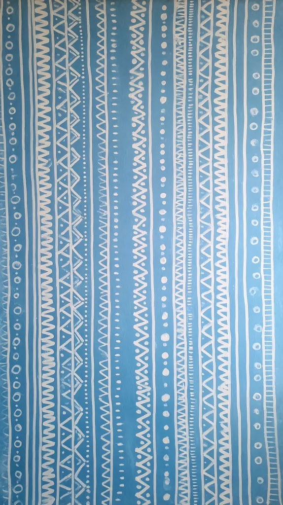 The image shows a textile design or artwork featuring vertical stripes of various repeating patterns.  The background is a light teal blue, and the patterns are in off-white, creating a striking contrast.  The patterns include zigzags, dots, and other simple geometric shapes, reminiscent of tribal or folk art designs.  The overall effect is a visually textured and rhythmic repetition.