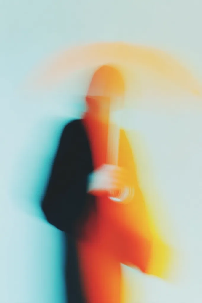 An abstract image depicts a blurry figure holding an umbrella. The colors are vibrant, with blues, oranges, and yellows dominating the scene. The subject's features are indistinct, creating a sense of mystery and movement.  The overall effect is dreamlike and evocative, suggesting a feeling of motion and perhaps a moment captured in passing.