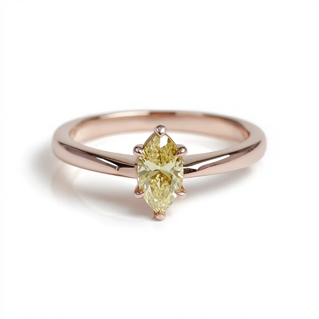 A delicate rose gold ring showcases a captivating marquise-cut yellow diamond.  The diamond is centrally set, its light golden hue catching the light.  The simple band complements the gemstone's elegance, making it a sophisticated and understated piece of jewelry.  The ring rests on a clean white background, highlighting its refined details.