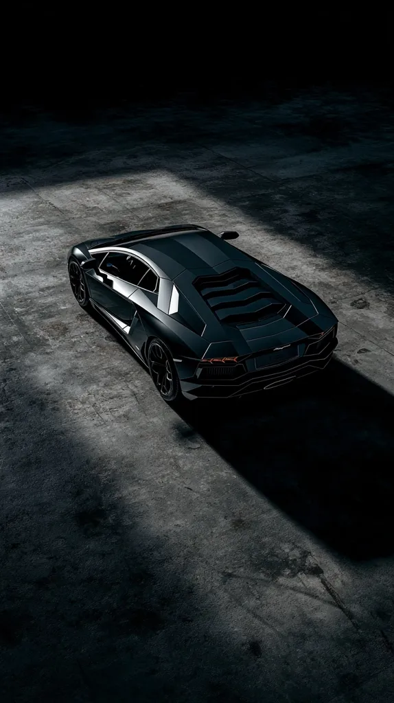 A dark gray Lamborghini Aventador sits in a dimly lit garage, angled slightly to the right.  A single beam of light illuminates the car, highlighting its sleek lines and powerful form against the rough concrete floor. The shadows create a dramatic contrast, emphasizing the car's luxurious design. The overall mood is one of mystery and sophistication.