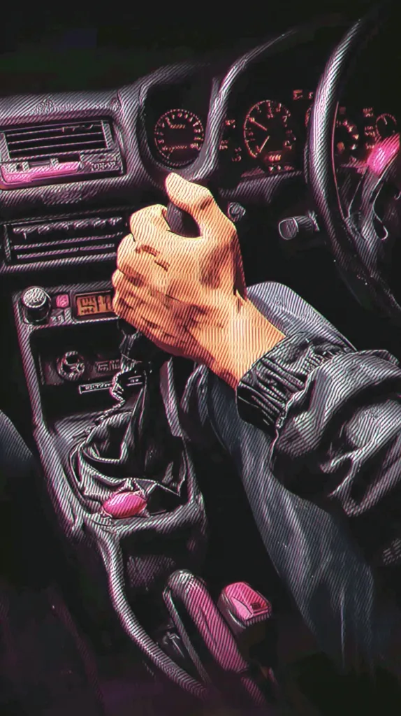 A stylized illustration depicts a hand gripping a manual gearshift inside a car.  The interior is dark, illuminated by glowing pink accents on the dashboard and console.  The image emphasizes the texture of the car's materials and the driver's hand, creating a gritty, retro aesthetic reminiscent of 1980s or 90s car culture.  The focus is on the act of driving, conveying a sense of motion and control.